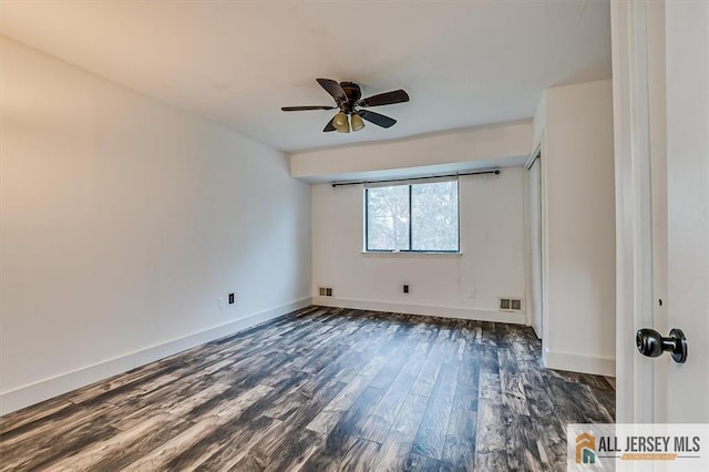 unfurnished room with baseboards, ceiling fan, dark wood-type flooring, and visible vents