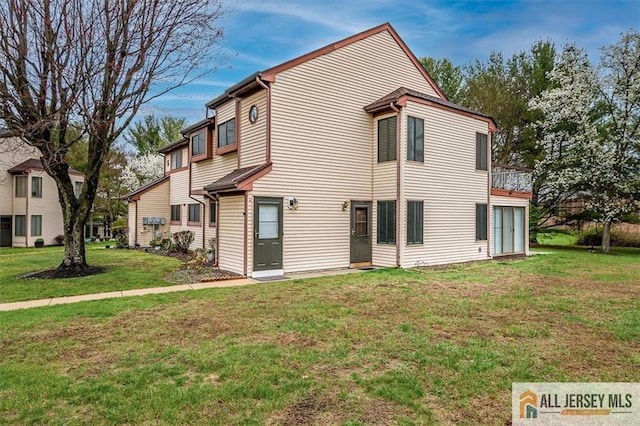 rear view of property featuring a lawn