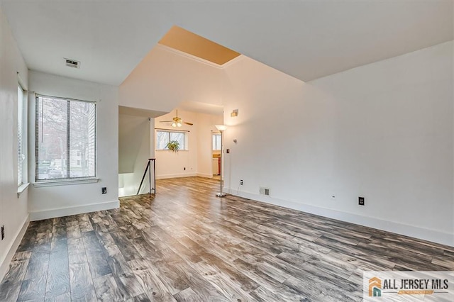unfurnished living room featuring baseboards, a ceiling fan, wood finished floors, and visible vents