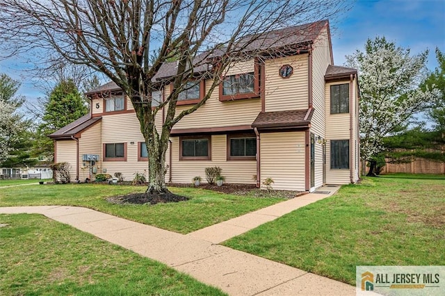 view of front of home with a front lawn and roof with shingles