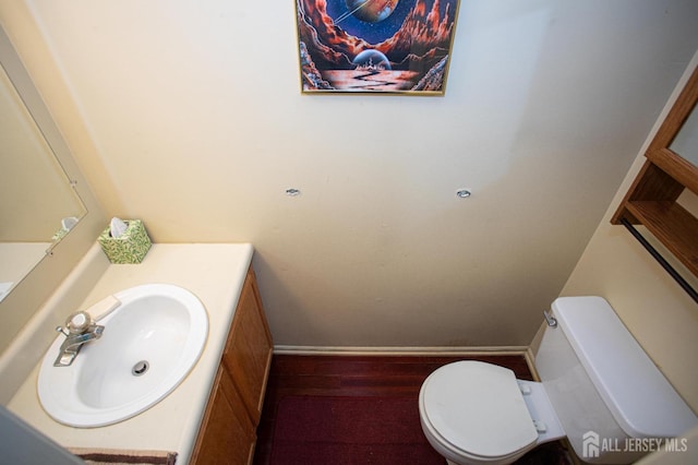 bathroom with vanity, toilet, and wood-type flooring