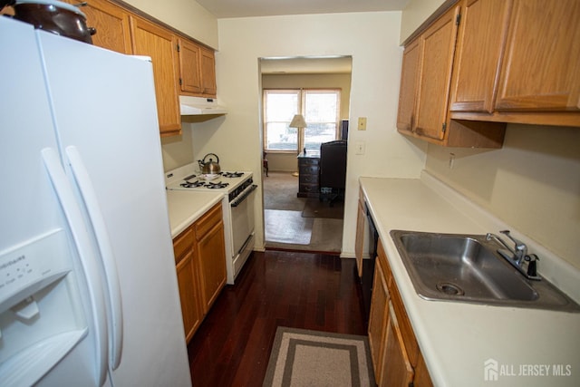 kitchen featuring white appliances, dark hardwood / wood-style floors, and sink