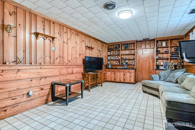 1056 Kearney Dr, North Brunswick, NJ 08902 - living area with wooden walls, built in shelves, light tile patterned floors, and crown molding