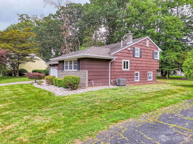 1056 Kearney Dr, North Brunswick, NJ 08902 - view of side of home featuring a yard, a chimney, an attached garage, and roof with shingles