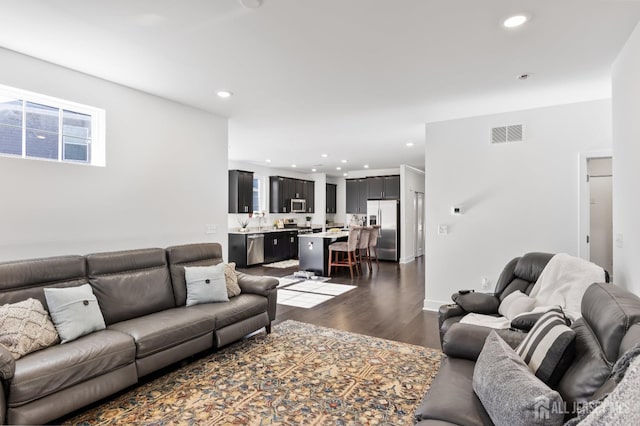 living area featuring visible vents, recessed lighting, and dark wood finished floors