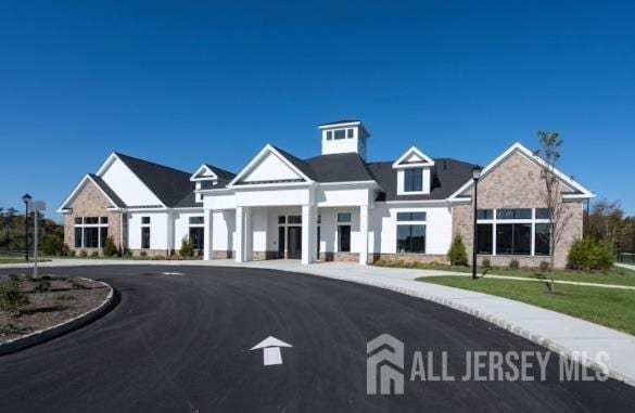view of front of house featuring curved driveway and stone siding