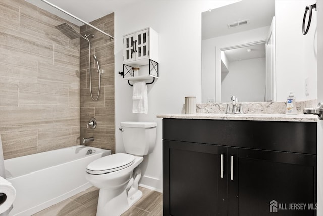 full bathroom featuring visible vents, vanity, wood finished floors, toilet, and washtub / shower combination