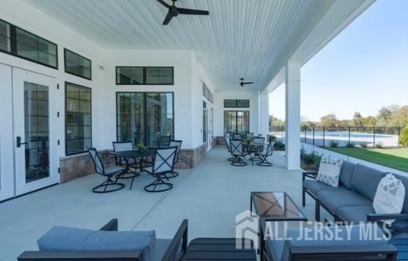 view of patio / terrace with fence, an outdoor living space, a ceiling fan, and outdoor dining area