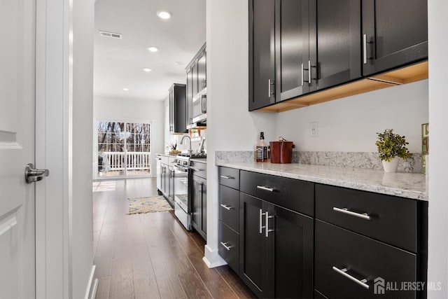 bar featuring recessed lighting, visible vents, dark wood-style floors, and stainless steel gas stove