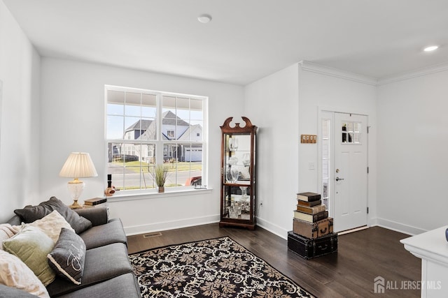living area featuring crown molding, dark wood-style flooring, and baseboards