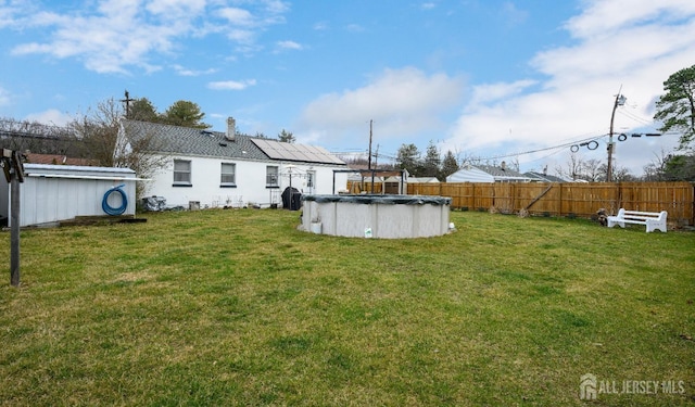 view of yard featuring fence and a fenced in pool