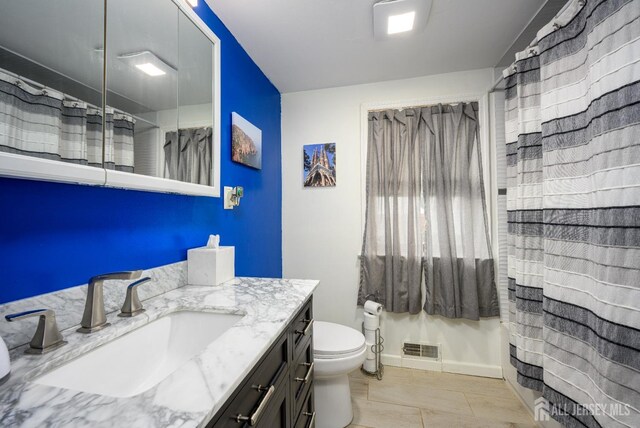 bathroom with vanity, toilet, and curtained shower