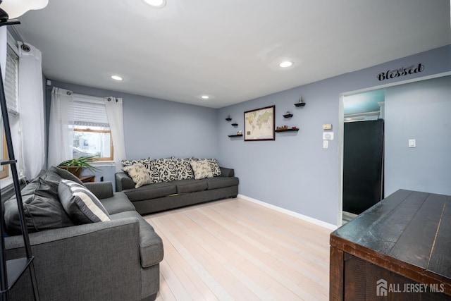 living area with baseboards, wood finished floors, and recessed lighting