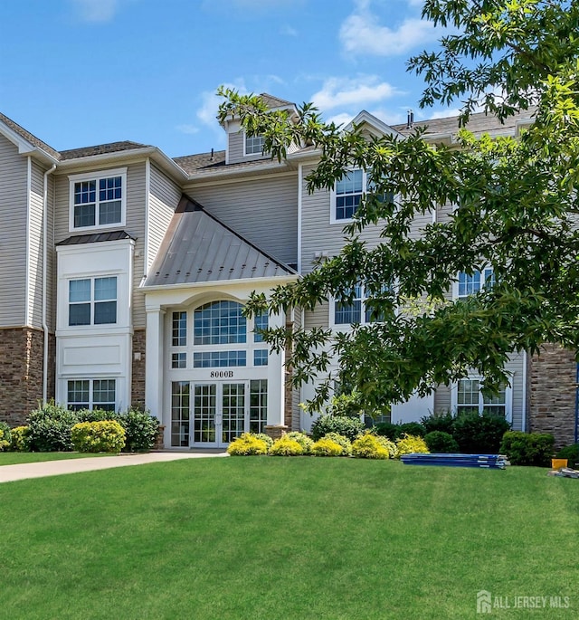 view of front of home with a front lawn and french doors