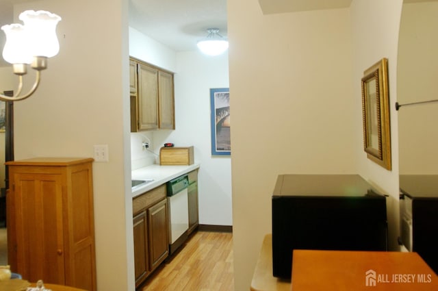 422 Ravens Crest Dr, Plainsboro, NJ 08536 - kitchen with dishwasher, light wood-style flooring, light countertops, a chandelier, and baseboards