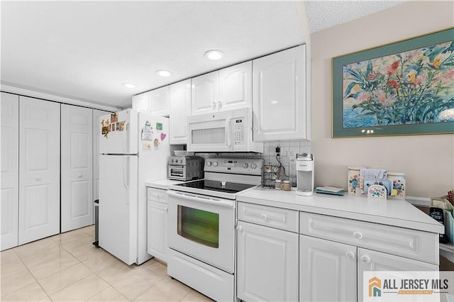 180 Mimosa Plz Unit 180A, Monroe, NJ 08831 - kitchen with white appliances, white cabinets, light countertops, recessed lighting, and light tile patterned flooring