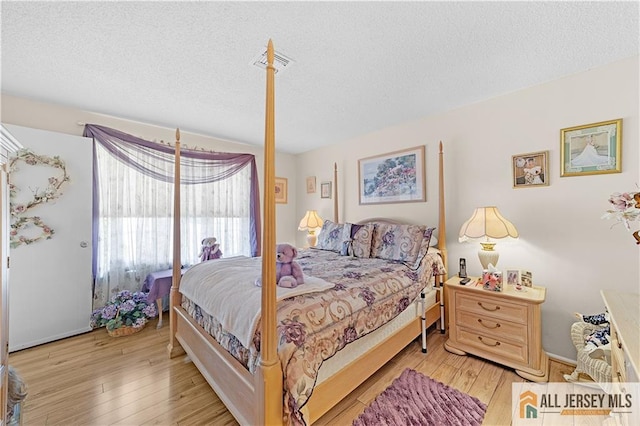 180 Mimosa Plz Unit 180A, Monroe, NJ 08831 - bedroom featuring a textured ceiling, wood finished floors, and baseboards
