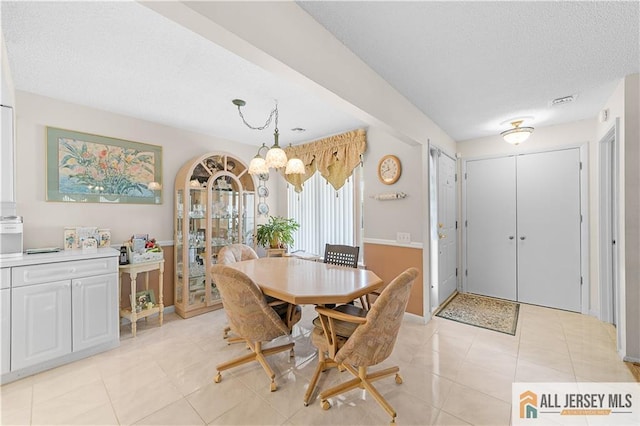 180 Mimosa Plz Unit 180A, Monroe, NJ 08831 - dining room featuring a chandelier, light tile patterned floors, a textured ceiling, and baseboards
