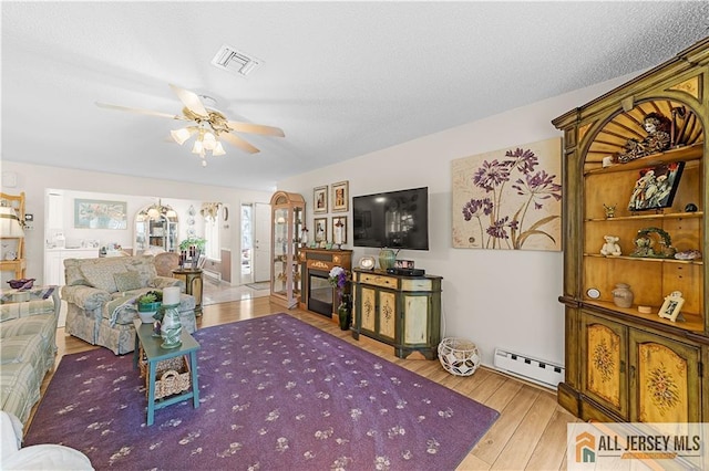 180 Mimosa Plz Unit 180A, Monroe, NJ 08831 - living room featuring a baseboard heating unit, wood finished floors, and ceiling fan