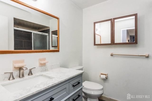 bathroom with toilet, vanity, and a stall shower