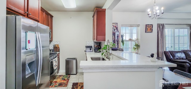 548 E Celebration Way E, South Plainfield, NJ 07080 - kitchen featuring stainless steel appliances, reddish brown cabinets, open floor plan, a peninsula, and a chandelier
