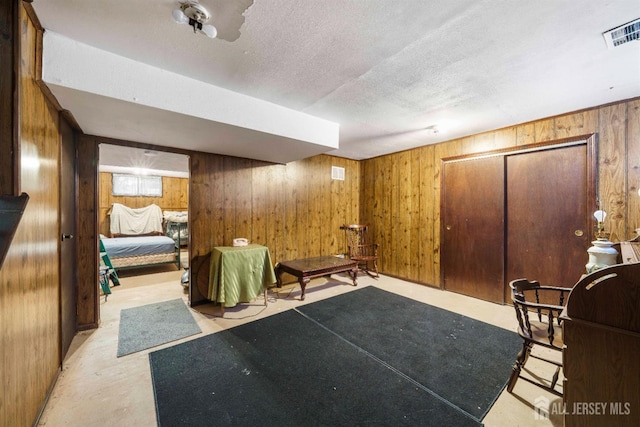 77 Highview Dr, Woodbridge Proper, NJ 07095 - sitting room with wooden walls, a textured ceiling, and concrete floors