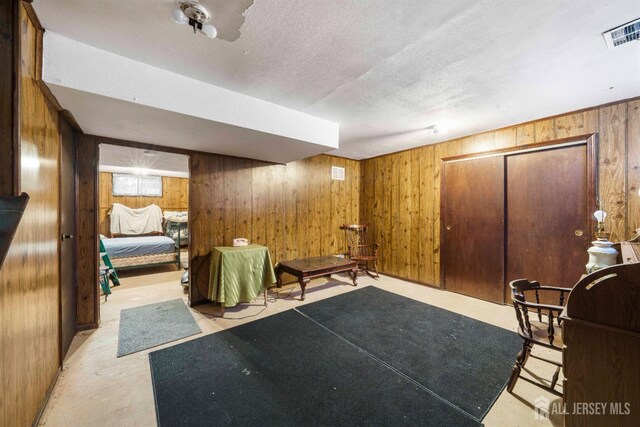 77 Highview Dr, Woodbridge Proper, NJ 07095 - living area featuring wooden walls, a textured ceiling, and concrete flooring