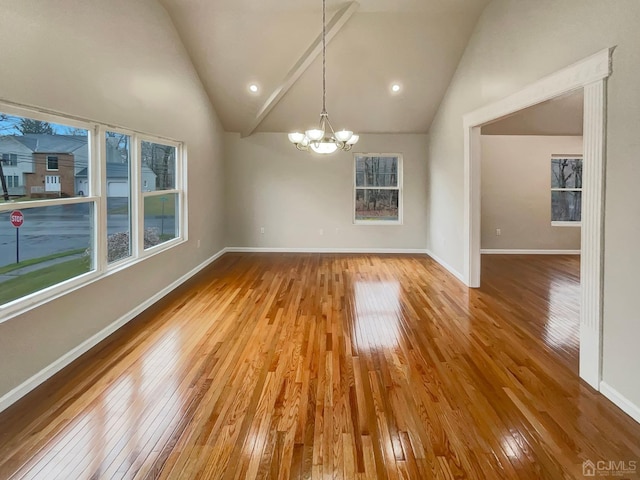 interior space featuring baseboards, wood-type flooring, a notable chandelier, and high vaulted ceiling