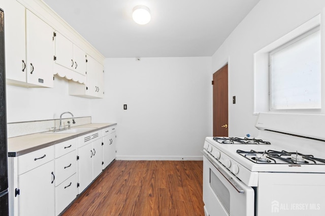 43 Jensen Ave, Fords, NJ 08863 - kitchen featuring white cabinets, dark wood-style flooring, a sink, light countertops, and white gas range