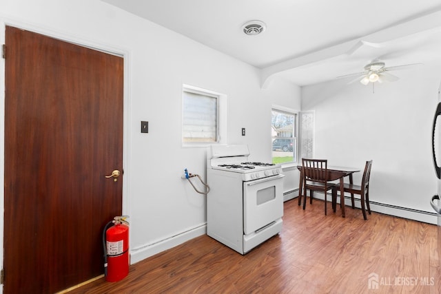 43 Jensen Ave, Fords, NJ 08863 - kitchen with ceiling fan, baseboard heating, wood finished floors, visible vents, and white range with gas cooktop