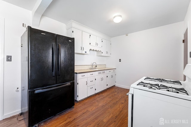 43 Jensen Ave, Fords, NJ 08863 - kitchen featuring white gas range oven, freestanding refrigerator, dark wood-style floors, and white cabinets