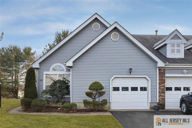 view of side of property featuring a garage, driveway, and brick siding