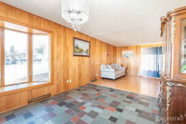 unfurnished room featuring a healthy amount of sunlight and wood walls