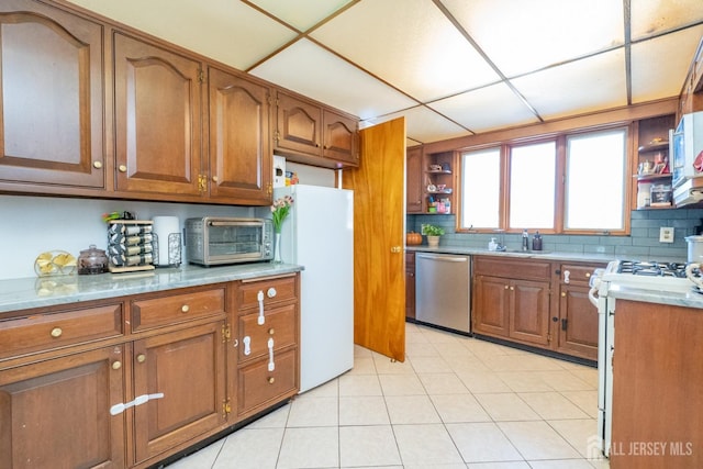 kitchen featuring open shelves, light countertops, brown cabinetry, a sink, and white appliances