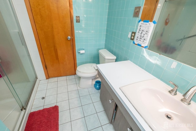 full bath with tile walls, tile patterned flooring, a shower stall, and vanity