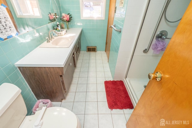 full bath featuring tile patterned flooring, visible vents, a shower stall, and tile walls