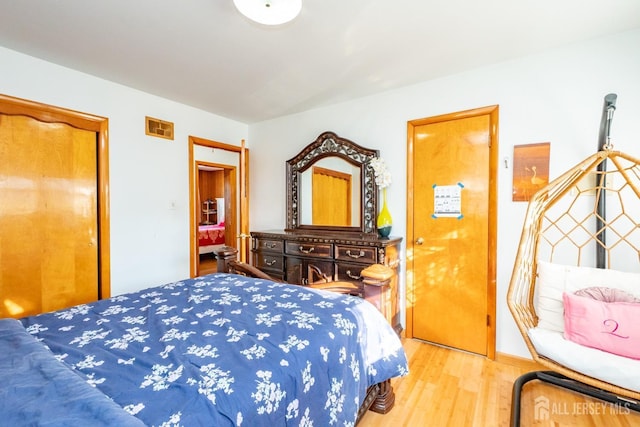 bedroom featuring visible vents and wood finished floors