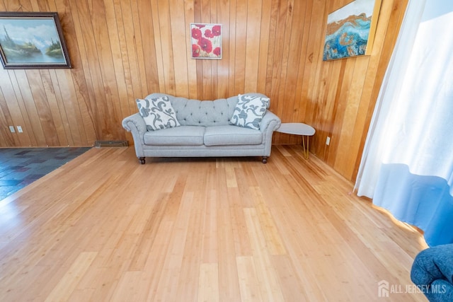 sitting room with wood walls and wood finished floors