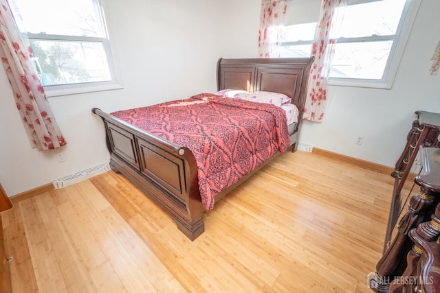 bedroom with light wood-style floors, visible vents, and baseboards