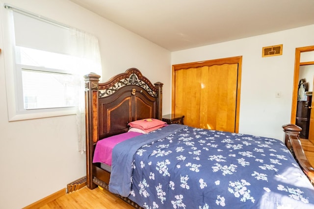 bedroom with a closet, baseboards, and wood finished floors