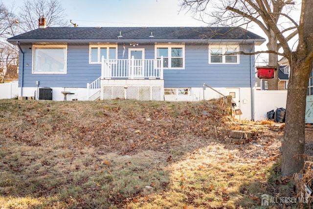 back of property featuring a chimney, central AC unit, a deck, and fence