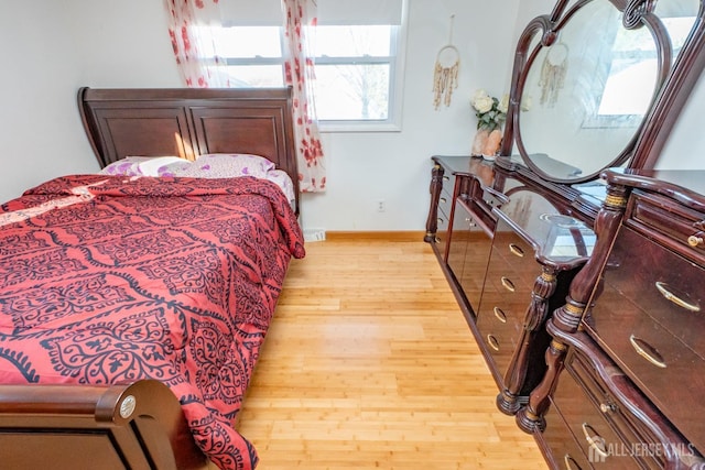 bedroom featuring baseboards and light wood finished floors