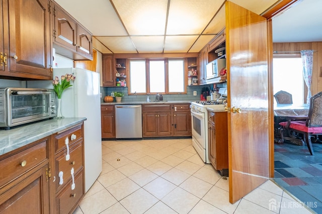 kitchen featuring white appliances, light countertops, a sink, and open shelves