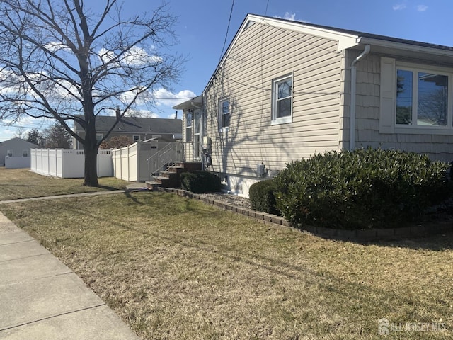 view of side of home featuring a yard and fence