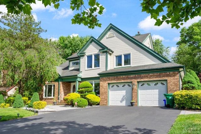 view of front of property with aphalt driveway, a garage, and brick siding