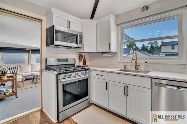 27 Collins Rd, Hamilton, NJ 08619 - kitchen with stainless steel appliances, a sink, light countertops, tasteful backsplash, and white cabinets