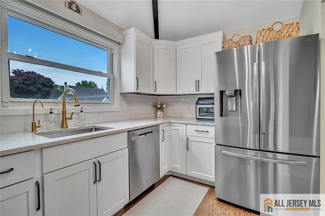 27 Collins Rd, Hamilton, NJ 08619 - kitchen with stainless steel appliances, a sink, white cabinetry, and decorative backsplash