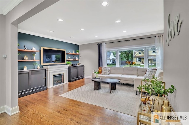 27 Collins Rd, Hamilton, NJ 08619 - living area featuring ornamental molding, recessed lighting, light wood finished floors, a glass covered fireplace, and baseboards