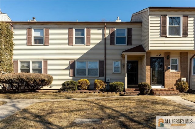 townhome / multi-family property with entry steps and brick siding