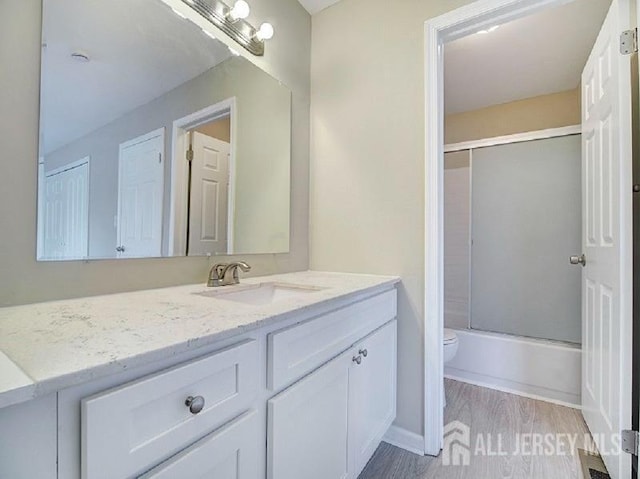 308 Pewter Ct, Old Bridge, NJ 08857 - full bath with toilet, vanity, wood finished floors, and bath / shower combo with glass door